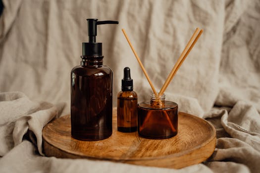 Aesthetic arrangement of amber glass bottles and diffuser sticks on a wooden tray, perfect for spa and relaxation themes.